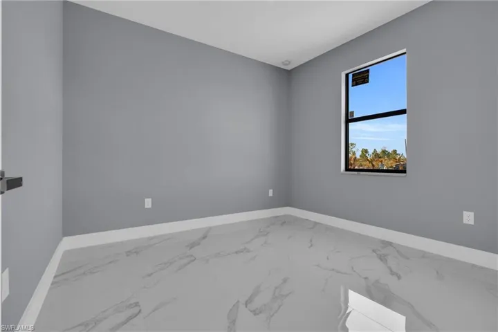 Unfurnished room featuring marble finish floors and baseboards