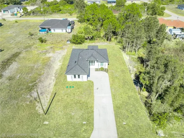 View of subject property with a tree filled landscape