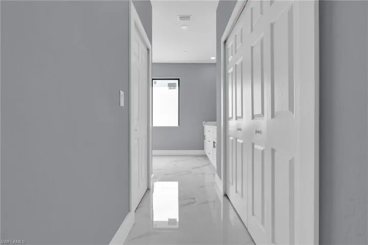 Corridor with recessed lighting and light marble finish flooring