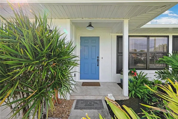 Property entrance with covered porch and stucco siding