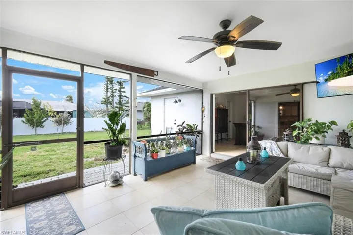 Sunroom / solarium with outdoor seating, ceiling fan, and a water view