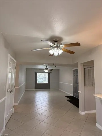 Empty room featuring light tile patterned floors and ceiling fan