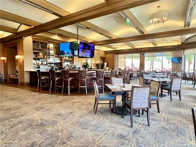 Dining room featuring beamed ceiling and a community bar