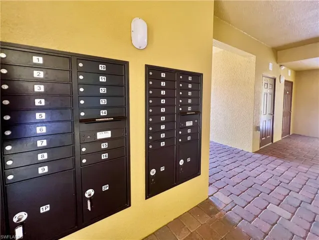 View of community featuring mail area, a textured ceiling, and a textured wall