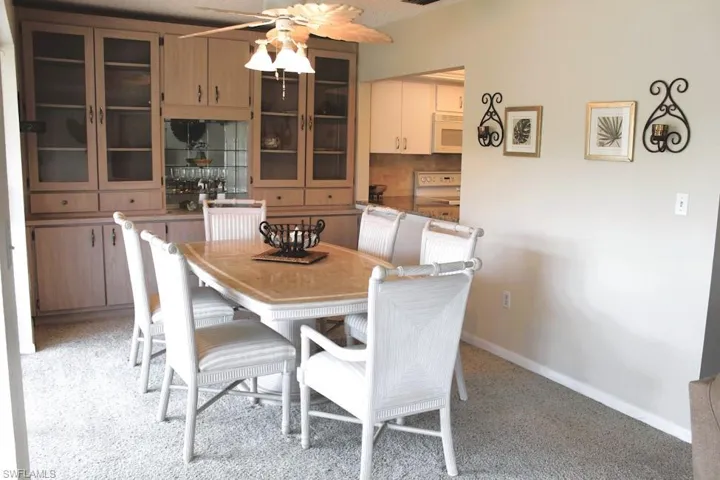 Dining room featuring ceiling fan and light carpet