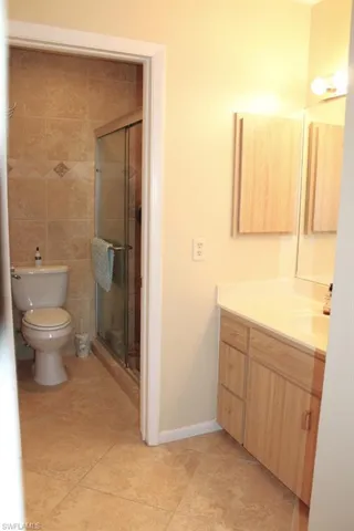 Full bath featuring vanity, tile patterned flooring, and a stall shower