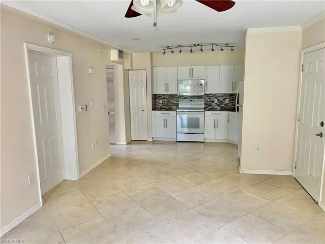 Kitchenette featuring white cabinetry, stainless steel appliances, and a mosaic tile backsplash