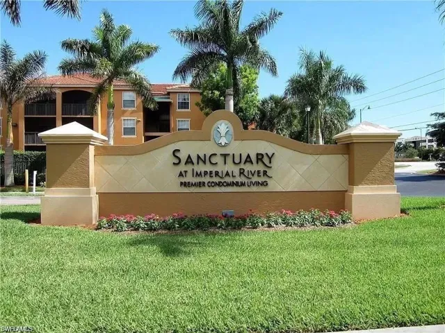 Sanctuary at Imperial River community entrance sign featuring decorative stonework and low-lying landscaping