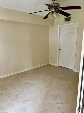 Neutral-toned tile flooring extends throughout the space, complemented by light-colored walls and white baseboards