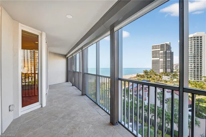 Unfurnished sunroom featuring a water view and a city view