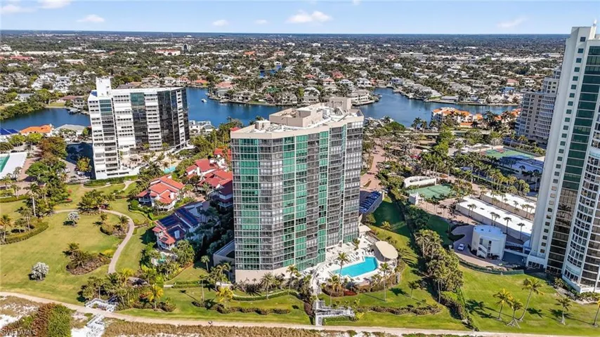 View of urban area with a nearby body of water and a pool