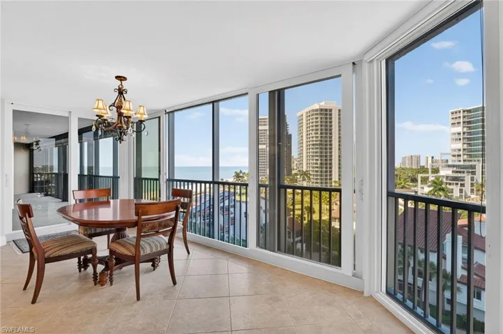 Dining area featuring plenty of natural light, a chandelier, expansive windows, a water view, and light tile patterned floors