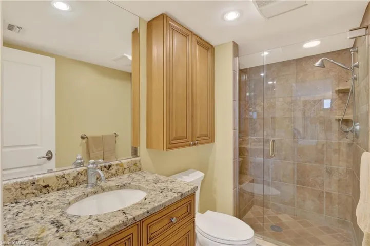Bathroom with vanity, a stall shower, and recessed lighting