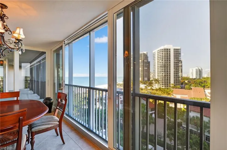 Sunroom / solarium featuring a water view, a city view, and hanging lights