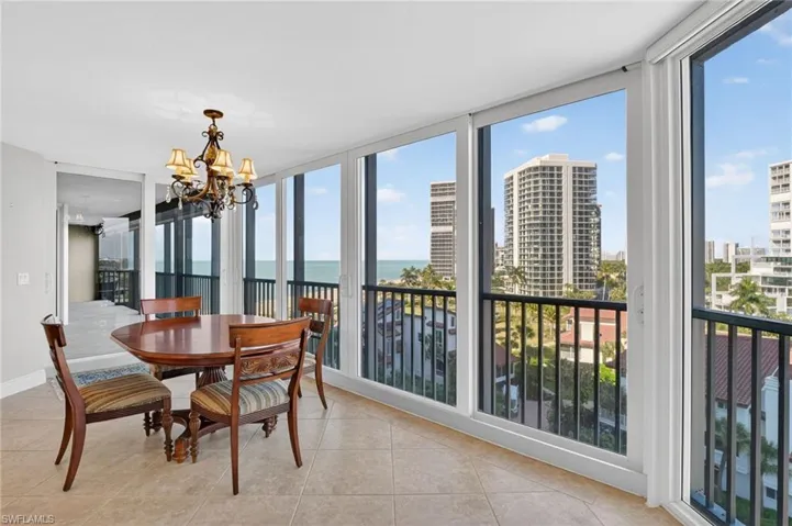 Dining area with expansive windows, suspended lighting, a water view, light tile patterned flooring, and a city view