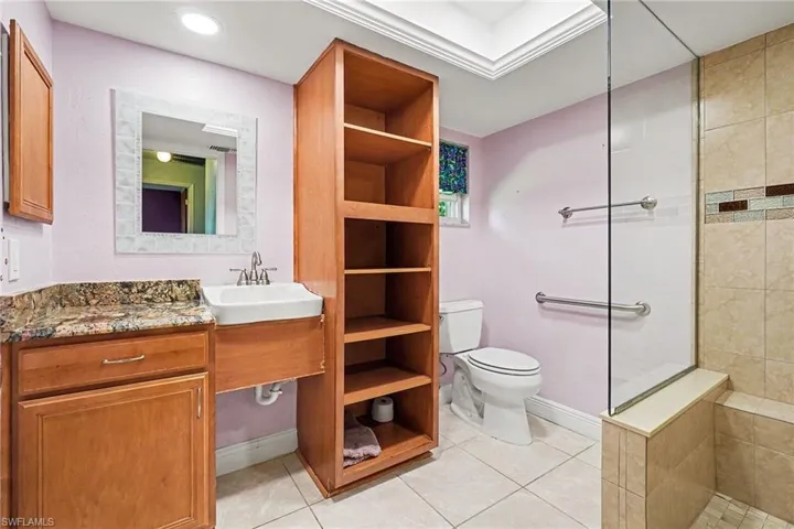 The bathroom is quite large with bright white lighting