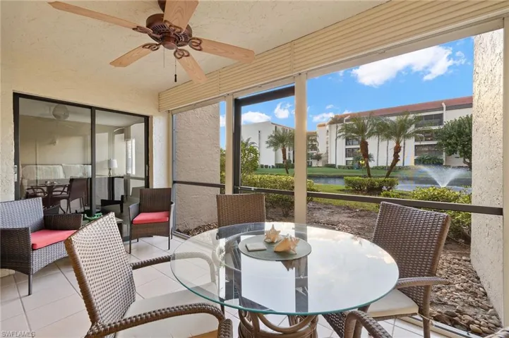 Sunroom / solarium featuring ceiling fan and a water view