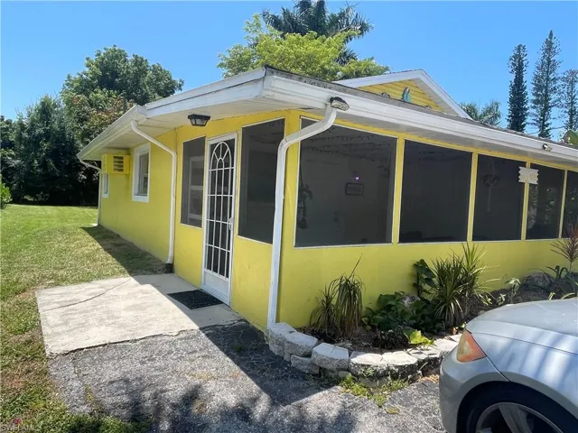 View of home's exterior featuring a yard and a sunroom