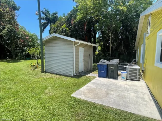 View of yard featuring a storage unit, a patio area, and central air condition unit