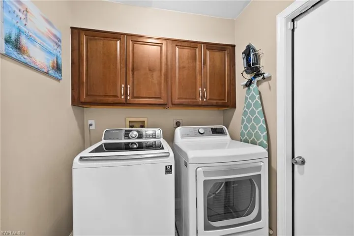 Laundry room with storage space leading to garage