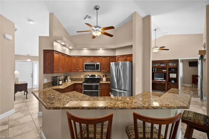 Open kitchen with large center island & breakfast bar.