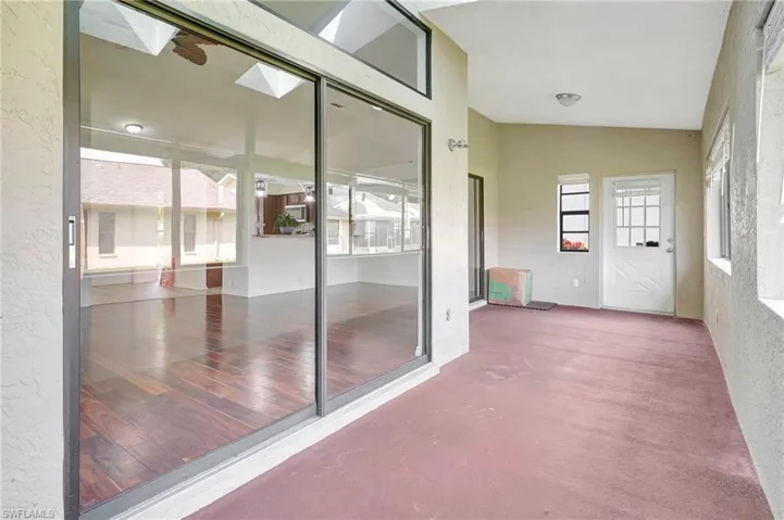 Unfurnished sunroom featuring lofted ceiling with skylight