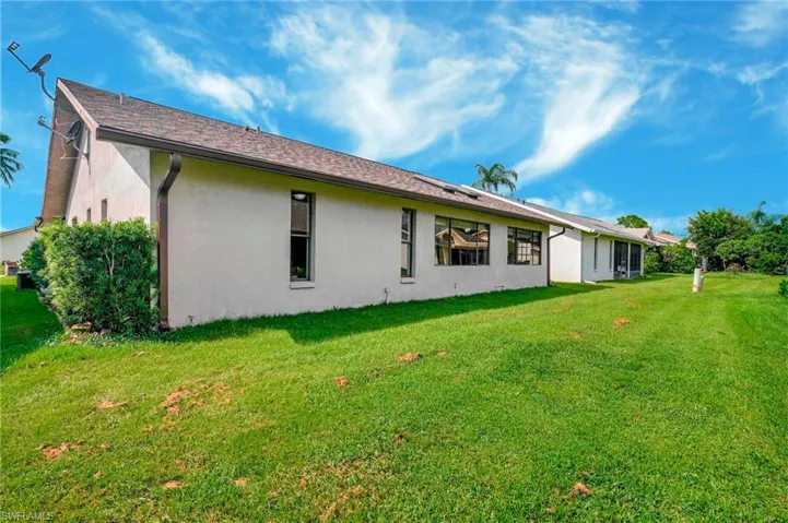 Back of house with a yard