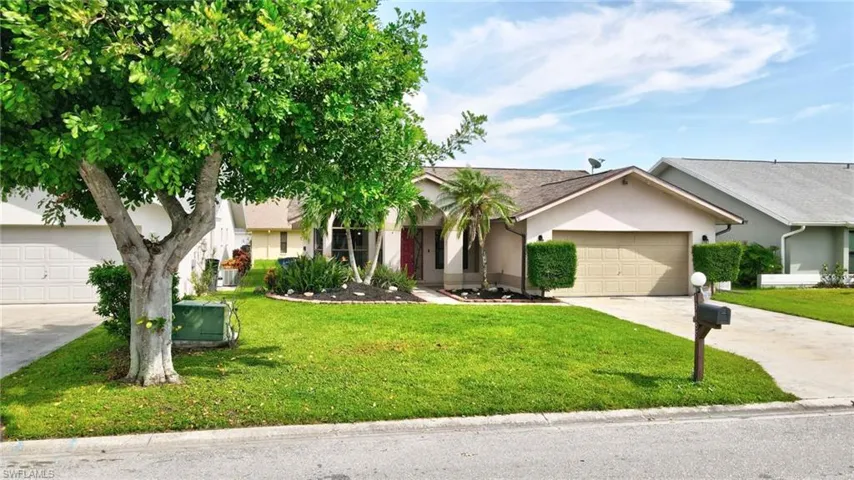 View of front of home with a garage and a front lawn