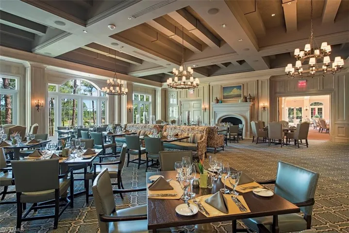 Dining space with a chandelier, beam ceiling, coffered ceiling, carpet, and crown molding