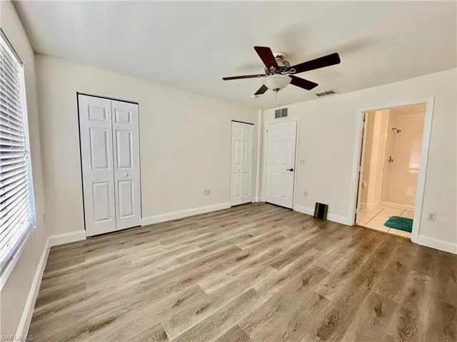 View of the Primary Bedroom corner showing full wall closetry dual bifolds, door entrance from second floor hallway and door entrance into Primary Bath