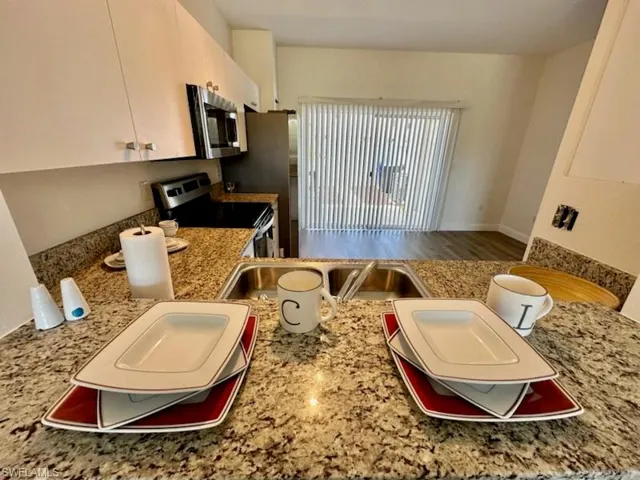 View of the granite breakfast bar into its kitchen and slider to rear yard