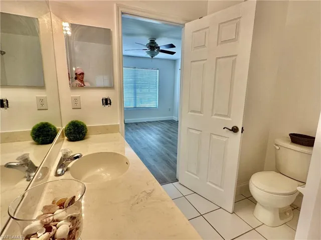 View from NEWLY TILED SHOWER showing toilet and doorway to Primary Bedroom
