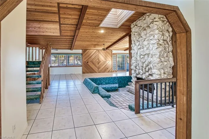 Front entry view from foyer-soaring cedar wood ceilings, Skylight and pecan rock fireplace