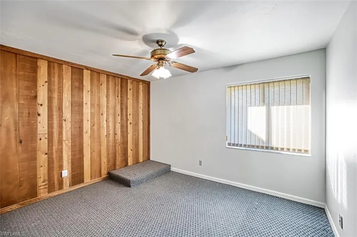 One of 3 ground floor bedrooms with Cedar accent wall, carpet and ceiling fan