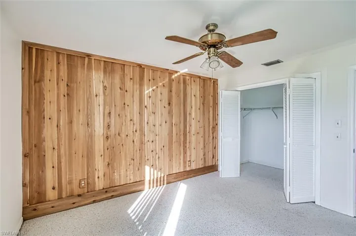 Ground floor Bedroom 2 with Cedar accent wall, ceiling fan,  arpeggio and walk-in closet