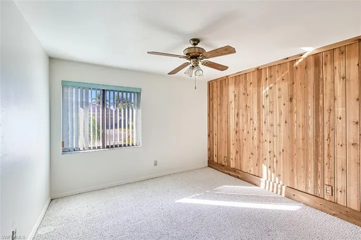 Ground floor bedroom 2 featuring cedar accent wall, carpet, ceiling fan and large closet