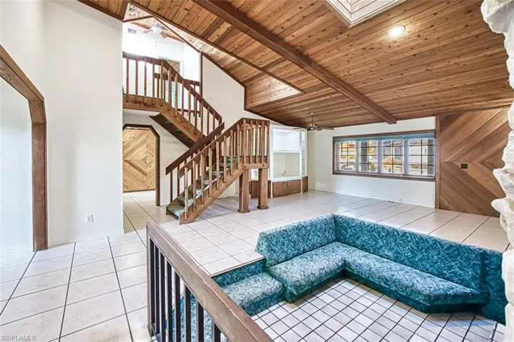 Wood staircase leads to primary bedroom, bath and balcony