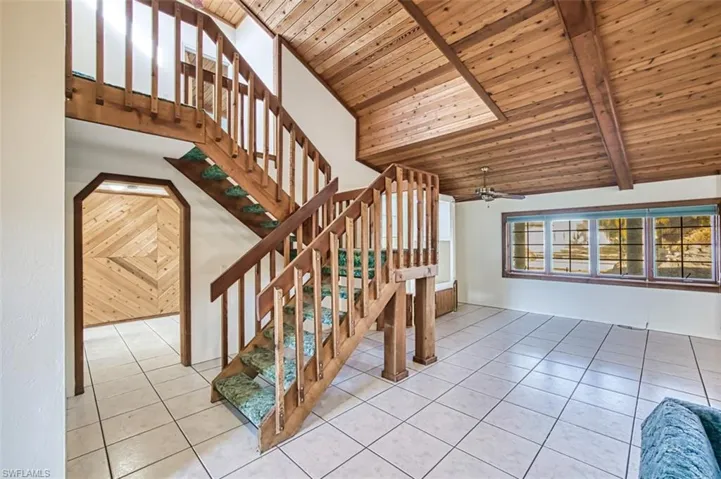 Staircase to Primary Bedroom and Balcony. Arch doorway leads to 3 ground floor bedrooms and pool bath.