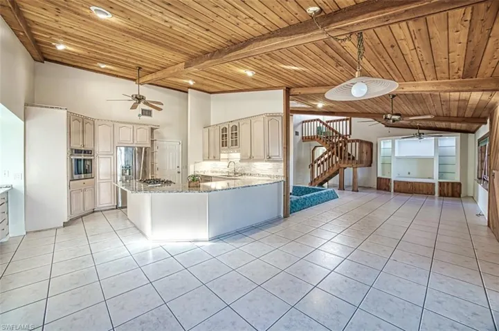 Open Kitchen, Dining and Living areas with recessed lighting and tile floor.