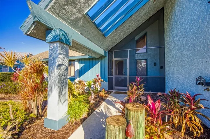 Unique custom home with front screened double door entry, tropical landscaping and circle drieway