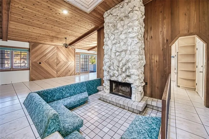 Sunken conversation pit with white "Pecan" rock wood burning fireplace and Skylight