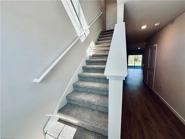 Stairs with hardwood / wood-style floors and recessed lighting
