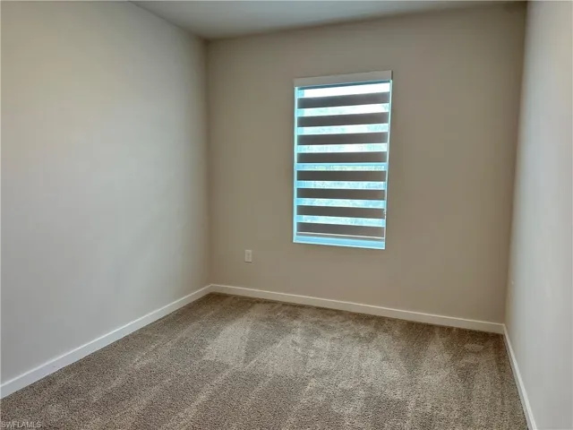 Spare room featuring carpet floors and baseboards