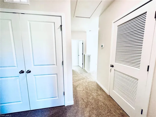 Corridor featuring carpet flooring and baseboards