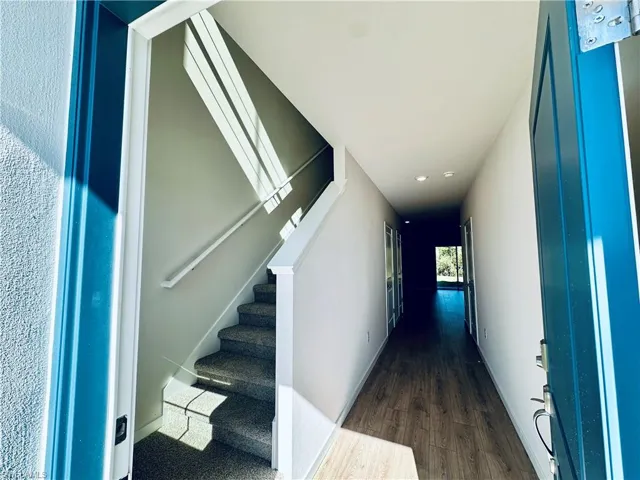 Stairway featuring wood finished floors and recessed lighting