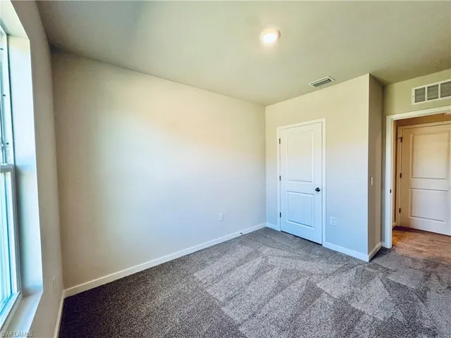 Unfurnished bedroom featuring baseboards and carpet