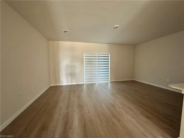 Unfurnished room featuring wood finished floors and baseboards