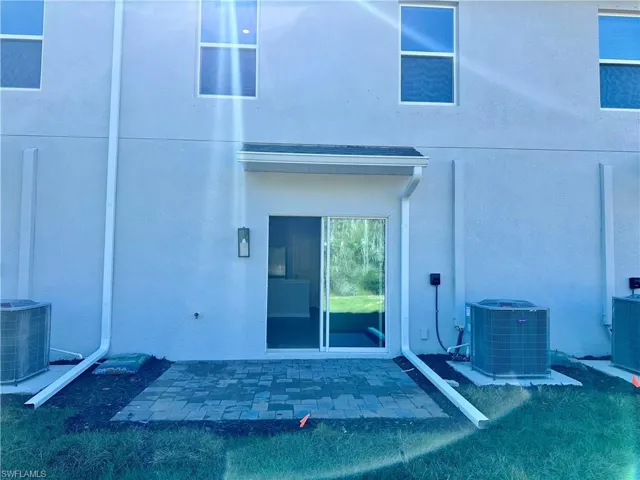 Property entrance with stucco siding and a patio