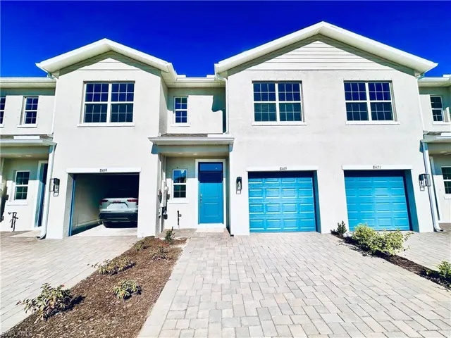 View of front facade featuring decorative driveway, an attached garage, and stucco siding