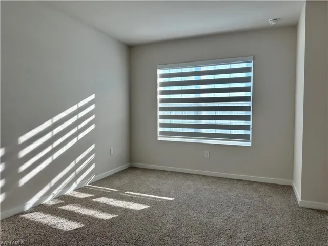 Unfurnished room with light carpet and baseboards